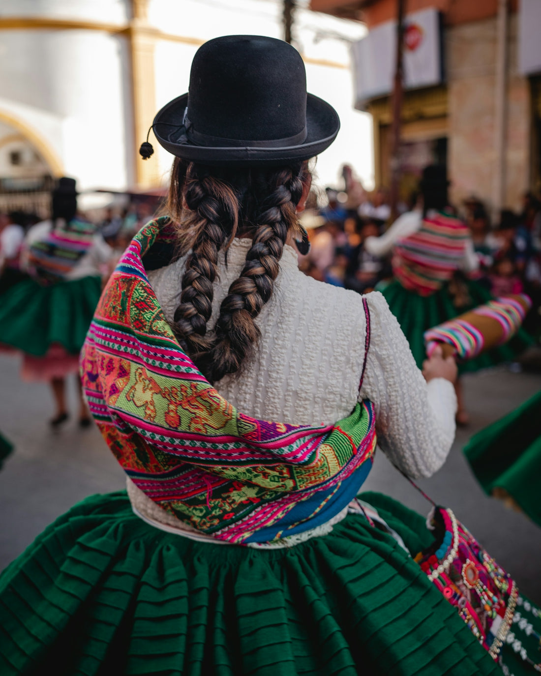 A woman in a black hat and green skirt